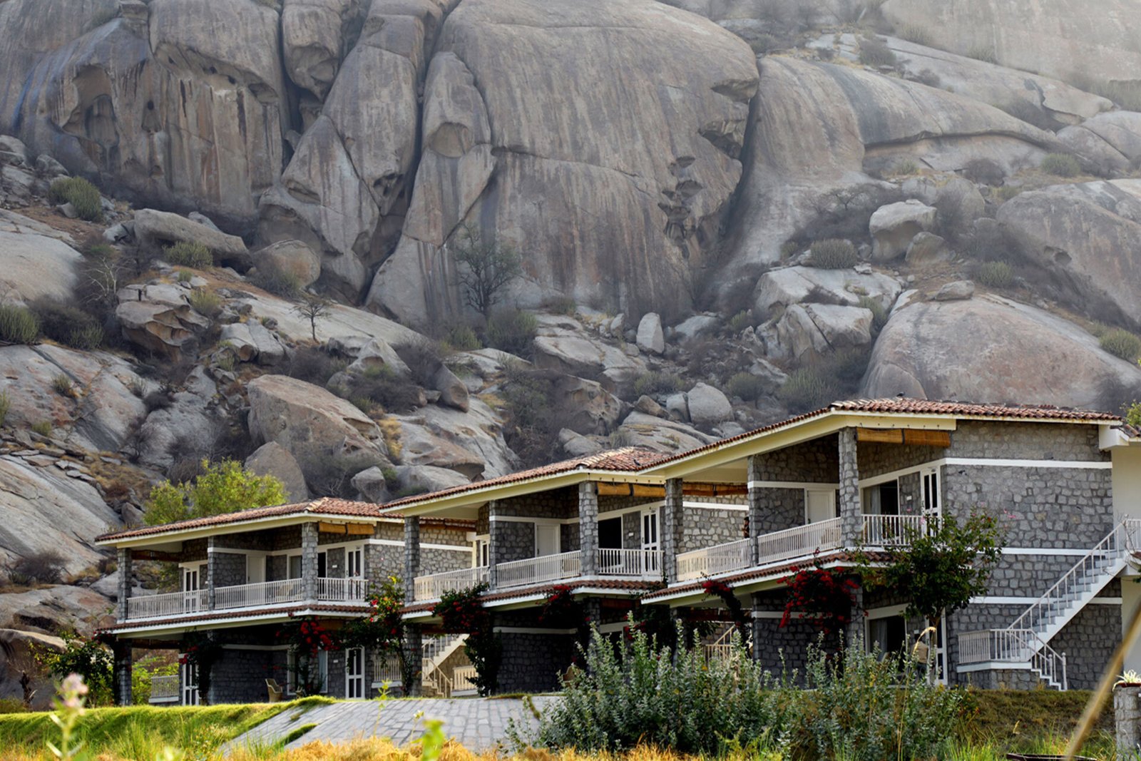 The Jawai Sagar resort rooms against granite rock formations